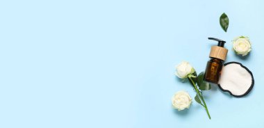 Beyaz güller, kozmetik ürünler şişesi ve mavi arkaplandaki pamuk yastık.