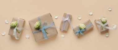 Bej arka planda güzel beyaz güller olan birçok hediye kutusu, üst manzara