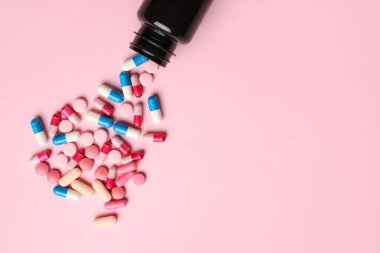 Pembe arka planda hapları olan şişe.
