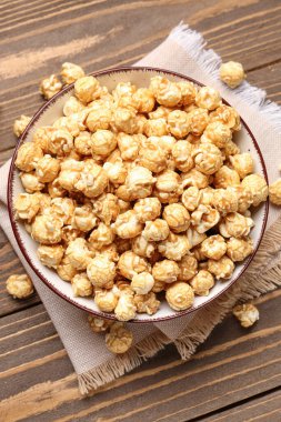 Tahta arka planda gevrek patlamış mısır kasesi.