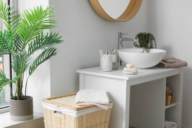 Lavabo lavabosu ve banyo aksesuarlarıyla dolu bir masa.