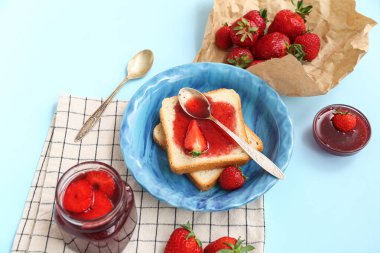 Çilek reçelli tatlı tost tabağı ve mavi arka planda taze böğürtlen