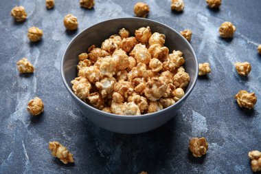 Mavi arka planda lezzetli patlamış mısır kasesi