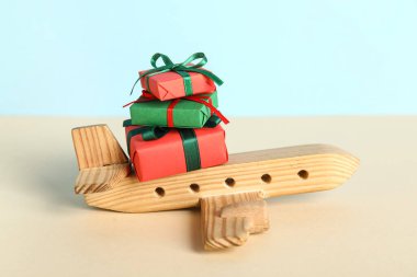 Ahşap uçak ve hediye kutuları mavi arka planda. Noel tatili konsepti
