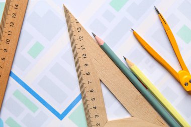 Rulers with pencils and pair of compasses on zoning plan, closeup