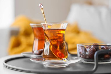 Bir bardak lezzetli Türk çayı ve masada hurma, yakın plan.