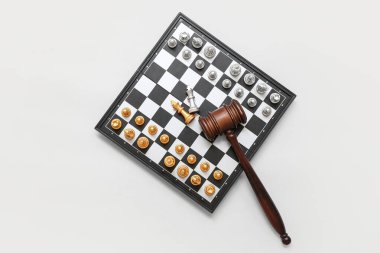 Satranç taşlı tahta ve beyaz arka planda yargıç tokmağı. Eşitlik kavramı
