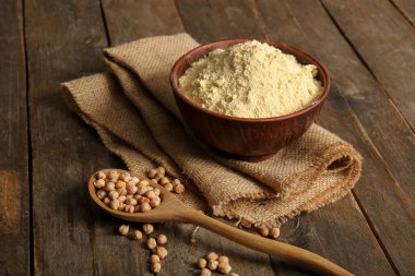 Bir kase nohut ve tahtadan arkaplanlı fasulye kaşığı.