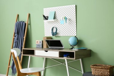 Renkli duvarda modern dizüstü bilgisayarı, küresi ve tahtasıyla rahat bir iş yeri