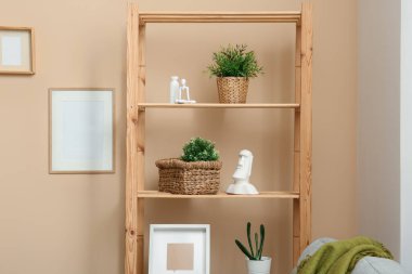 Hasır sepetli raflar ve bitkiler odada.