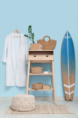 Masalı, çiçekli, bornozlu ve sörf tahtalı şık bir oda.