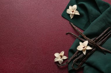 Renkli arkaplanda vanilya çubukları, çiçekler ve kumaş kompozisyonu