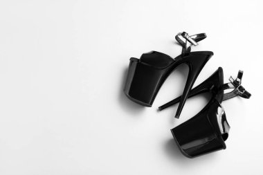 Gri arkaplanda striptiz dansı için şık siyah topuklular.