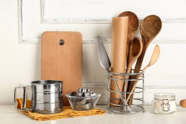 Farklı pişirme aletleri ve ışık masasında bir kavanoz un.