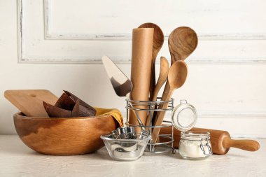 Farklı pişirme aletleri ve ışık masasında bir kavanoz un.