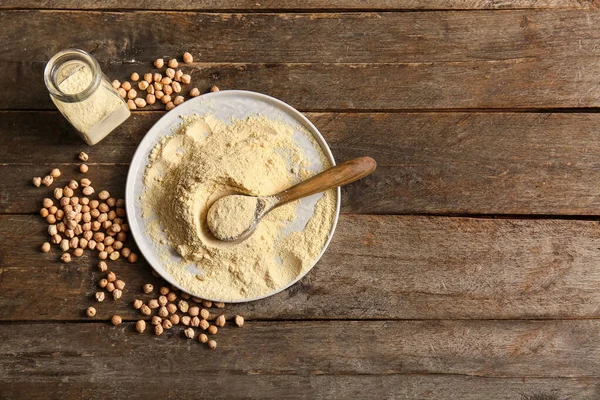 Kavanoz ve bir tabak nohut ve tahtadan arka planda fasulye.