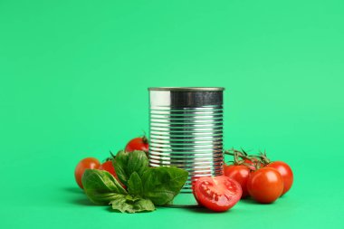 Domates ezmeli teneke kutu ve yeşil arka planda malzemeler, yakın plan.