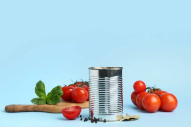 Mavi arka planda domates ezmeli teneke kutu ve malzemeler