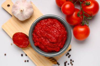 Bir kase lezzetli domates ezmesi, sarımsaklı ve biberli gri arka planda.