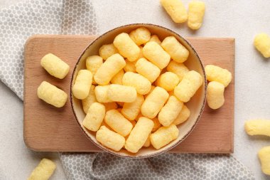 Beyaz arka planda mısır çubukları olan bir kase