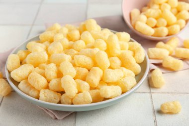 Beyaz fayanslı mısır çubukları olan tabak ve kase, yakın plan.