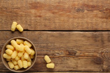 Tahta zemin üzerinde mısır çubukları olan bir kase.