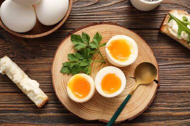 Kaynamış yumurta ve ahşap arka planda maydanozlu tahta.