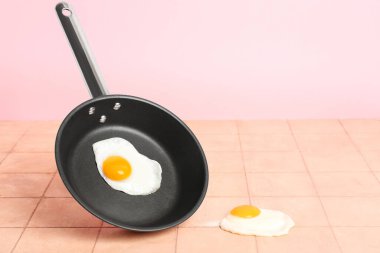 Bej döşeme masasında kızarmış yumurtalı kızartma tavası.