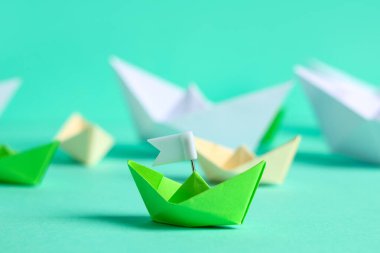 Biri bayrağı olan origami botu, diğeri de renkli arka planda.