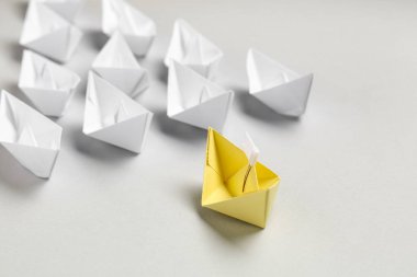 Sarı origami tekneli kompozisyon gri arkaplan üzerinde beyaz olanlar arasında
