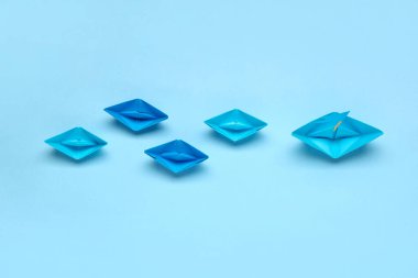 Renkli arka planda bayrakları olan bir origami teknesi. Liderlik kavramı
