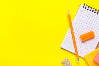 Different school stationery supplies with rubber erasers on yellow background
