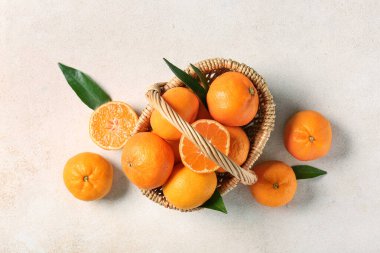 Beyaz arka planda tatlı mandalinalı hasır sepet