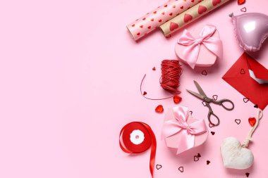İçinde mektup, dekor ve pembe arka planda ambalaj kağıtları olan hediye kutuları. Sevgililer Günü kutlaması