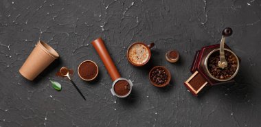 Kahve öğütücüsü, fincanlar, siyah grunge arka planında portafilter ve pudra ile kompozisyon