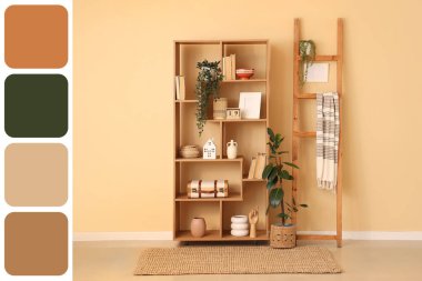 Kitaplı raf ünitesi, farklı dekorasyon ve merdiven. Odadaki bej duvarın yanında. Farklı renk desenleri