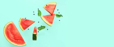 Uçan taze karpuz parçaları, nane ve tohumlar turkuaz arka planda ve metin için yer var