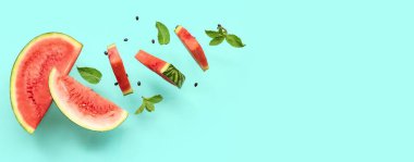 Uçan taze karpuz parçaları, nane ve tohumlar turkuaz arka planda ve metin için yer var