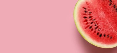 Pembe arkaplandaki lezzetli karpuzun yarısı metin ve üst görünüm için yer var.