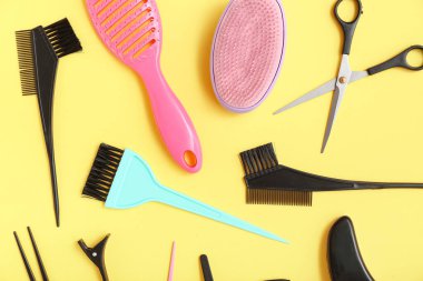 Sarı arka planda kuaför aksesuarları olan kompozisyon