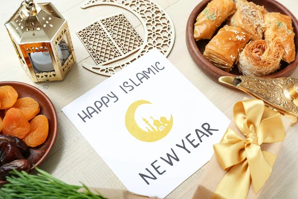 Beyaz ahşap arka planda Mutlu İslamcı Yeni Yıl, Tatlılar, Kresent ve hediye kutusu yazılı kart