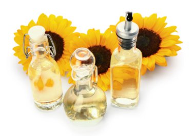 Beyaz zemin üzerinde ayçiçeği yağı olan şişeler ve sürahiler.