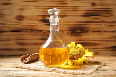 Ayçiçeği yağı ve tahtadan arka planda tohumları olan kepçe.