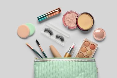 Beyaz arkaplanda dekoratif kozmetik ürünleri olan çanta