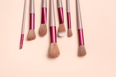 Pembe arka planda farklı makyaj fırçaları