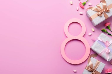 Hediye kutuları ve pembe arka planda güzel çiçekleri olan 8 numara. Uluslararası Kadınlar Günü