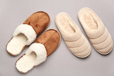 Gri arka planda iki çift yumuşak terlik. Üst görünüm