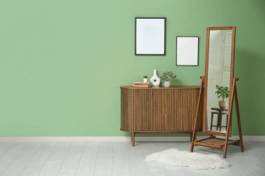 Çekmeceli, aynalı ve çerçeveli şık bir oturma odası.