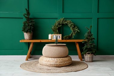 Odanın içinde Noel ağaçları, çelenkler ve ahşap banklar var.