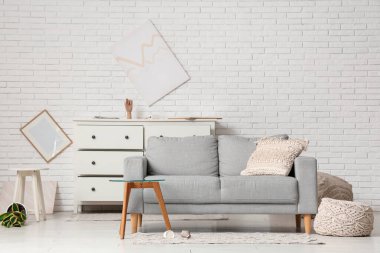 Depremden sonra gri kanepe ve kahve masası olan dağınık bir oturma odası.